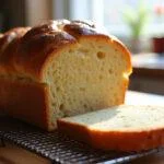 The final presentation of Bread 647, showcasing its crispy crust and soft interior on a cooling rack in a charming kitchen.
