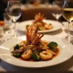 Elegant table setting with finished seafood medley, reflecting a premium seafood experience with wine and fine dining ambiance.